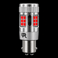 A silver metal automotive LED light bulb with red illuminated LED panels on the front, shown against a solid black background. A stylized 'R' logo is visible on the lower section of the bulb.